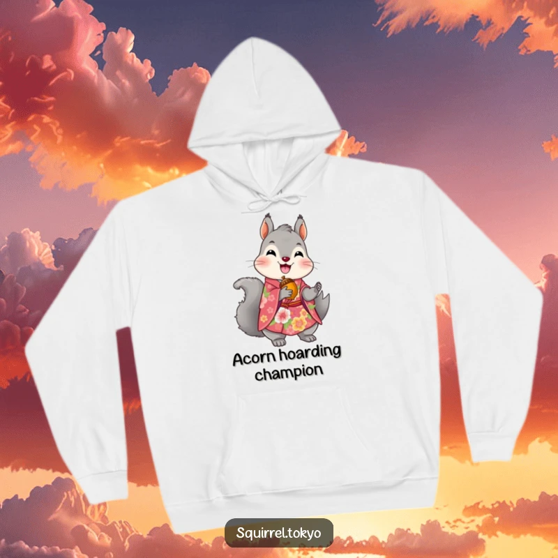 Funny hoodie depicting a delighted grey squirrel in a vibrant floral kimono, clutching a precious golden acorn, embodying cozy nature.